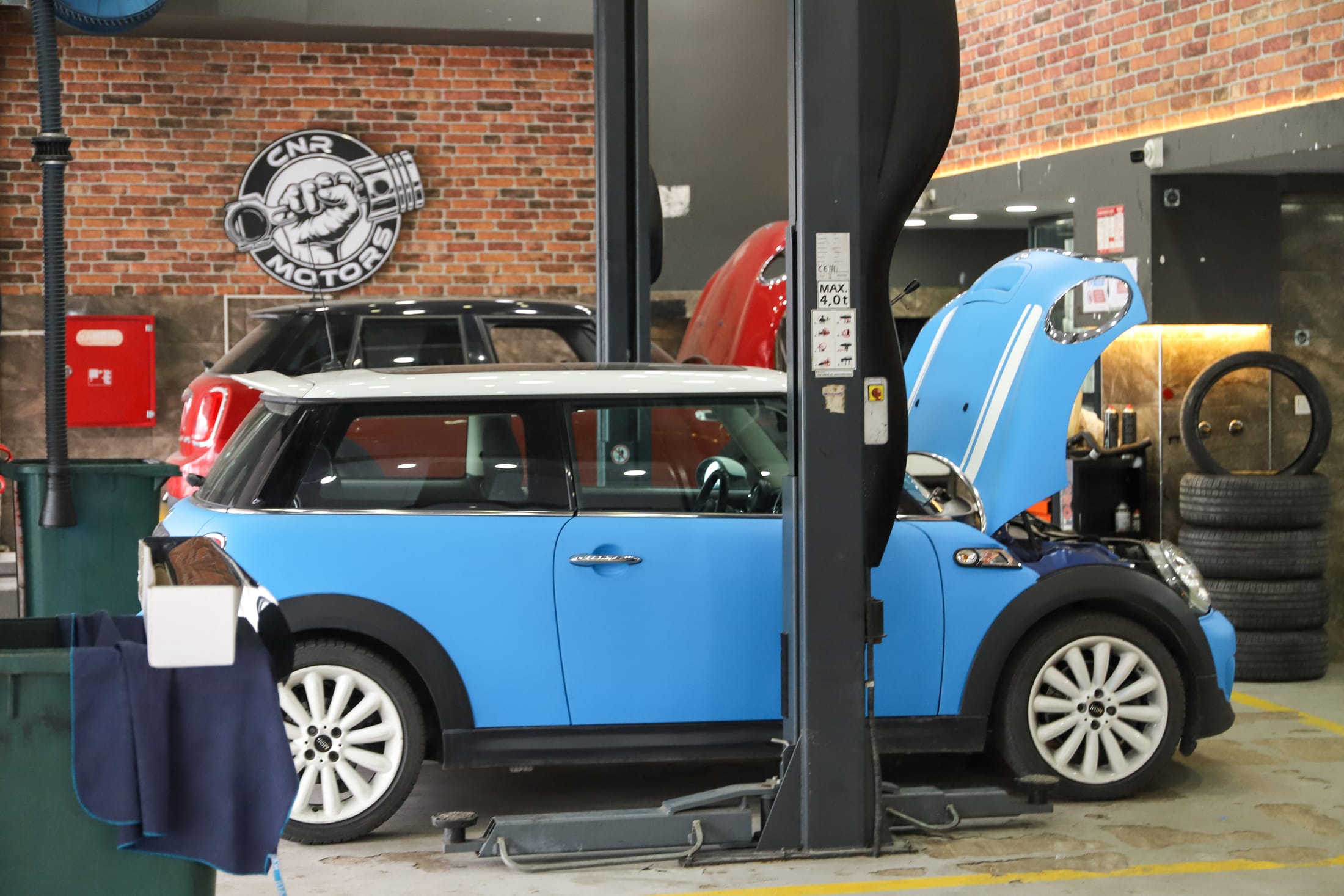 Servis liftinde bakımdaki mavi bir Mini